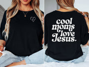 Model wearing a Cool Moms Love Jesus T Shirt showcasing heart design and trendy text on back.