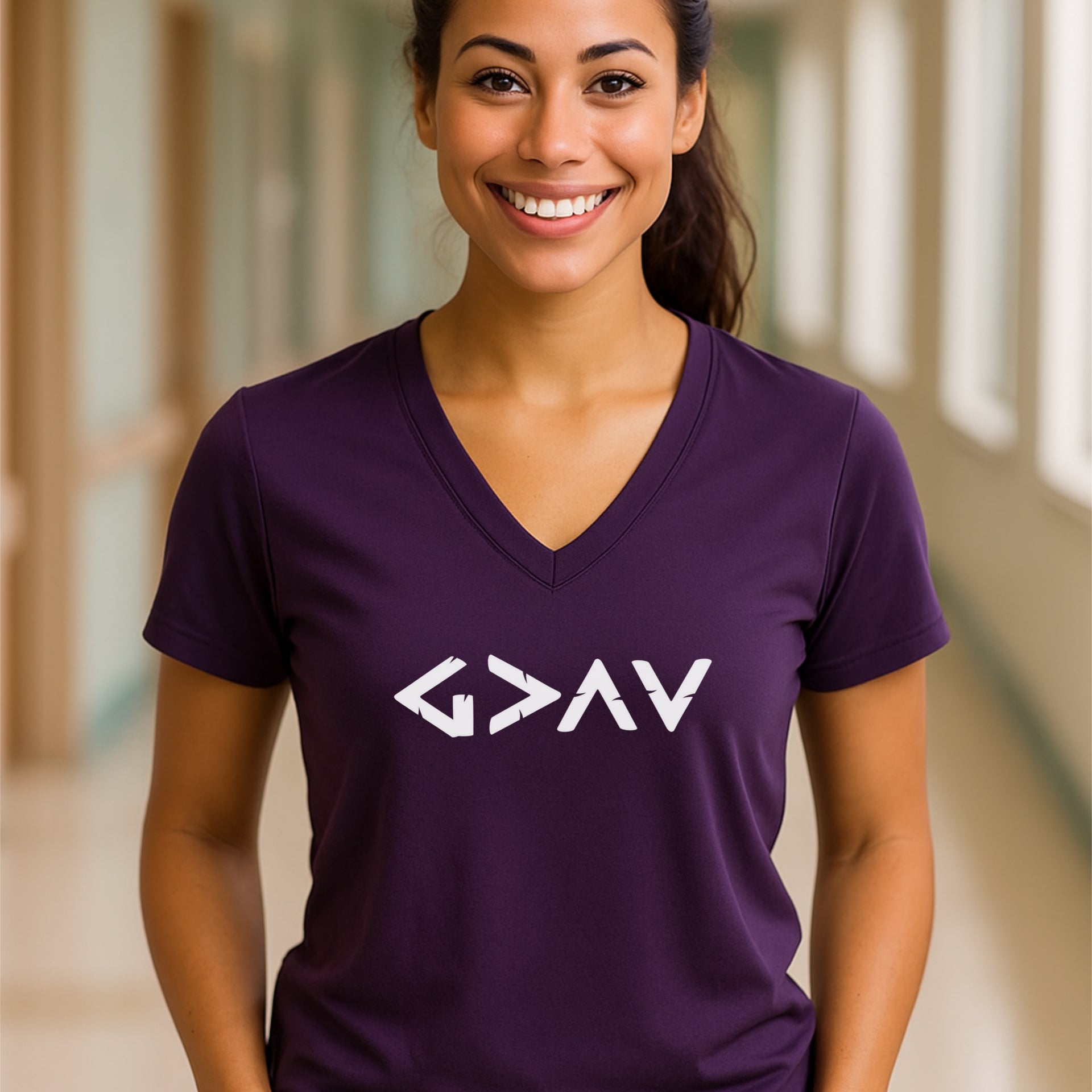 God Is Greater Than Highs And Lows V Neck Tee worn by a smiling woman in a purple shirt with geometric design.