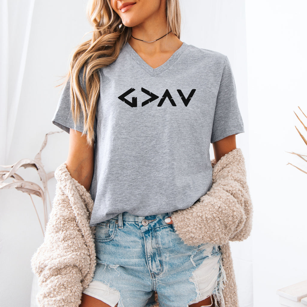 Model wearing God Is Greater Than Highs And Lows V Neck Tee in athletic heather, showcasing minimalist design with geometric symbol.