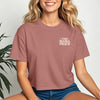 This Mama Prays Christian Crop Tee for Moms worn by a smiling woman, featuring a cropped fit and faith-inspired graphics.