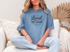 Model wearing a Loved by God T-Shirt, showcasing comfort and faith with a stylish design.