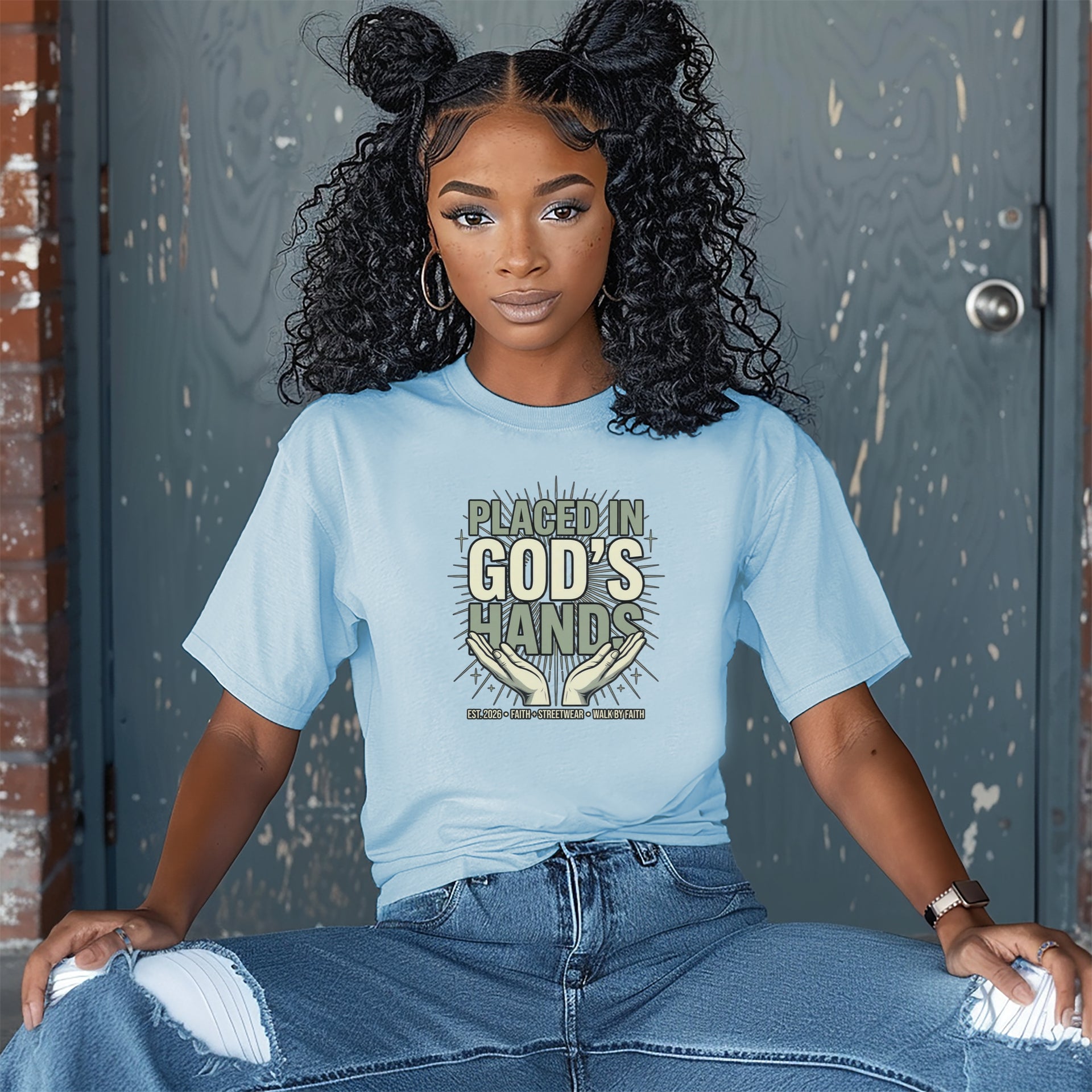 A woman wearing a light blue Placed in God's Hands T-Shirt, showcasing a message of faith and trust in God.