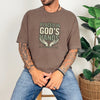 Placed in God's Hands T-Shirt worn by a model, featuring a comforting design with hands and uplifting text.