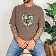 Placed in God's Hands T-Shirt worn by a model, featuring a comforting design with hands and uplifting text.