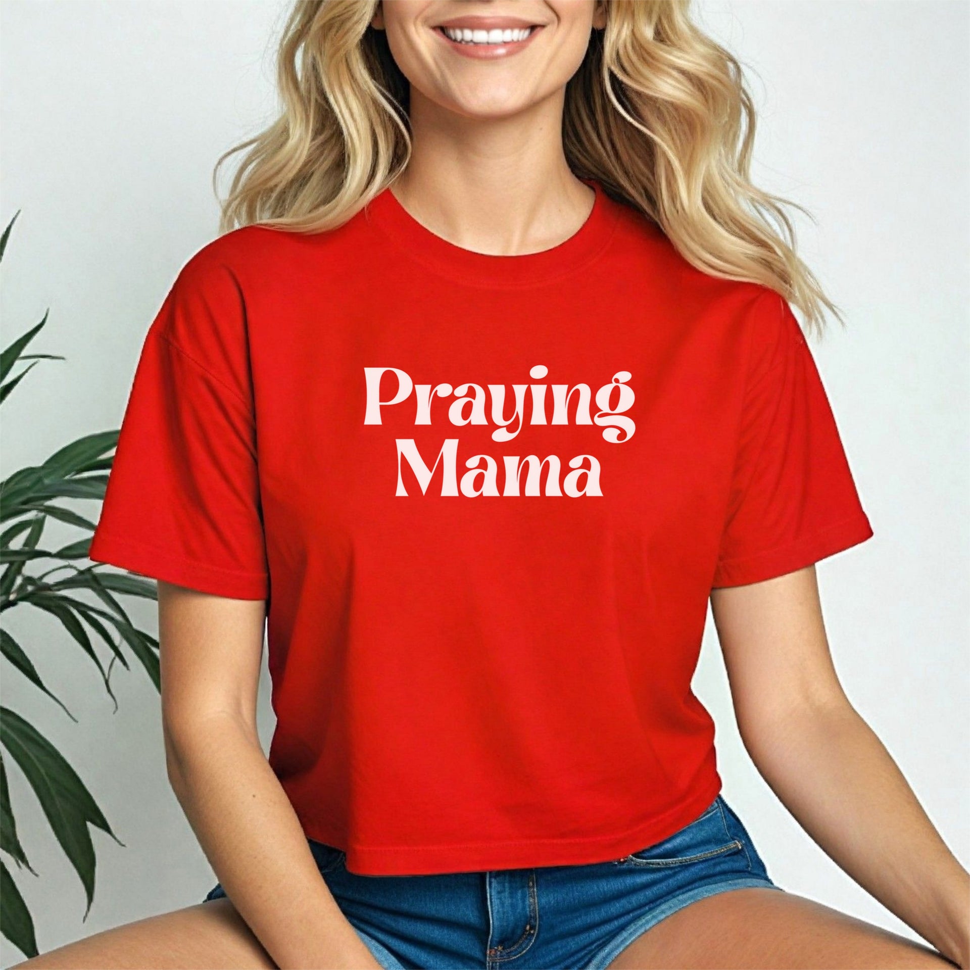 Model wearing a red Praying Mama Crop Tee, showcasing faith and style with a trendy cropped fit.