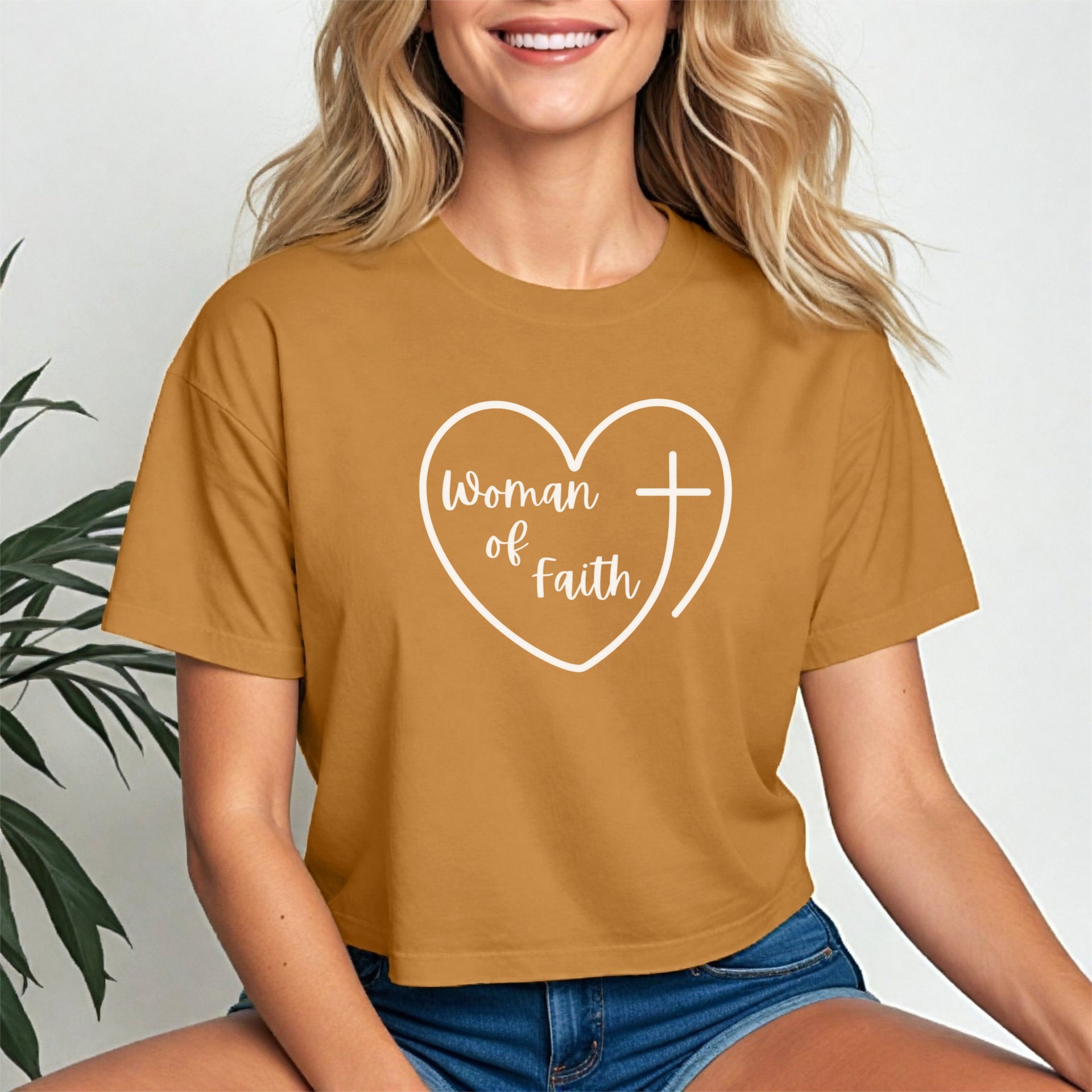 Woman Of Faith Heart Cross Crop Tee displayed on a model, featuring a heart and cross design in a modern cropped fit.