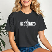 Redeemed Cross Graphic Crop Tee featuring a stylish cross design and trendy cropped fit on a model.
