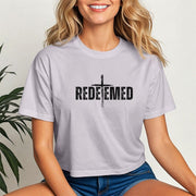 Woman wearing a Redeemed Cross Graphic Crop Tee with a cross design, showcasing faith and style.