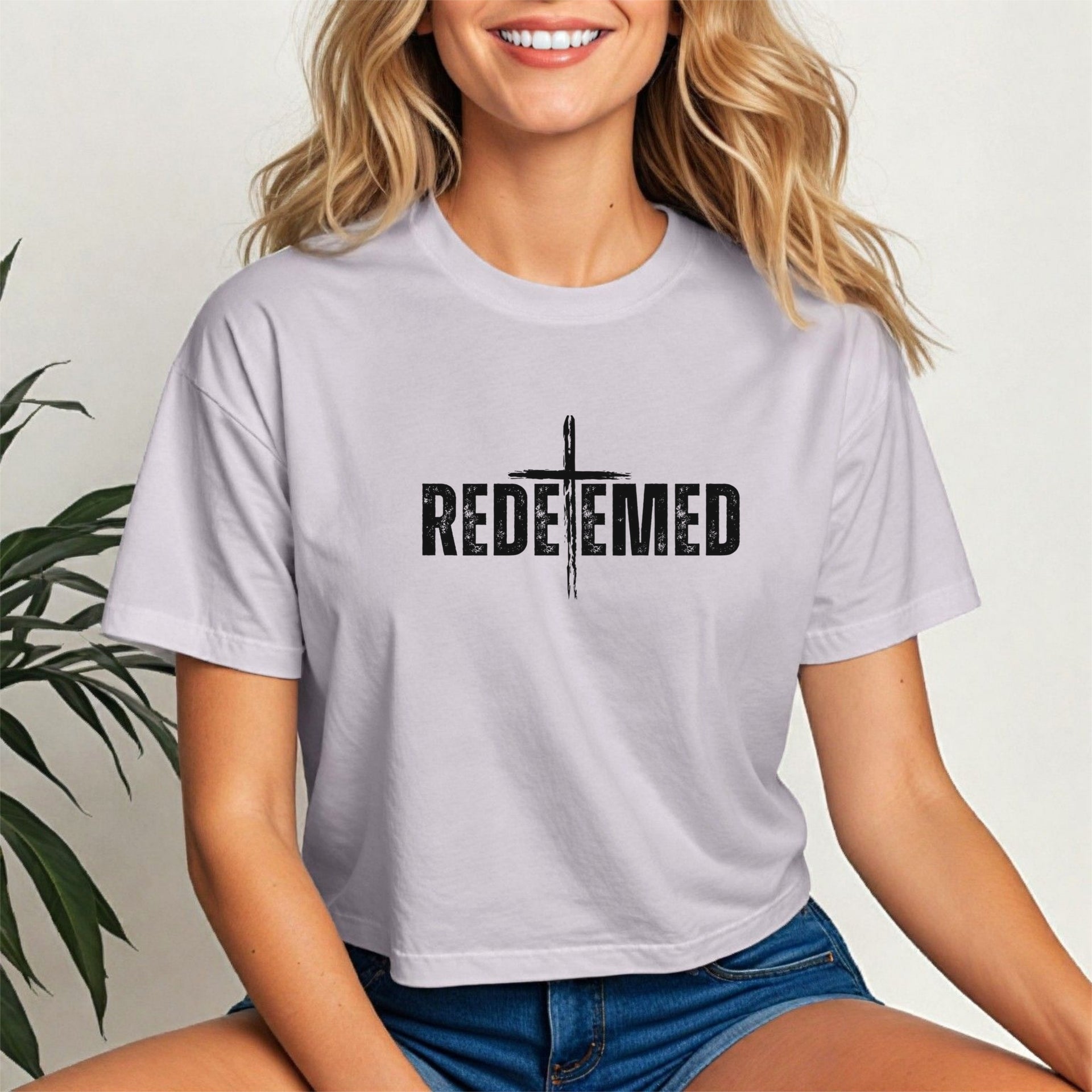 Woman wearing a Redeemed Cross Graphic Crop Tee with a cross design, showcasing faith and style.