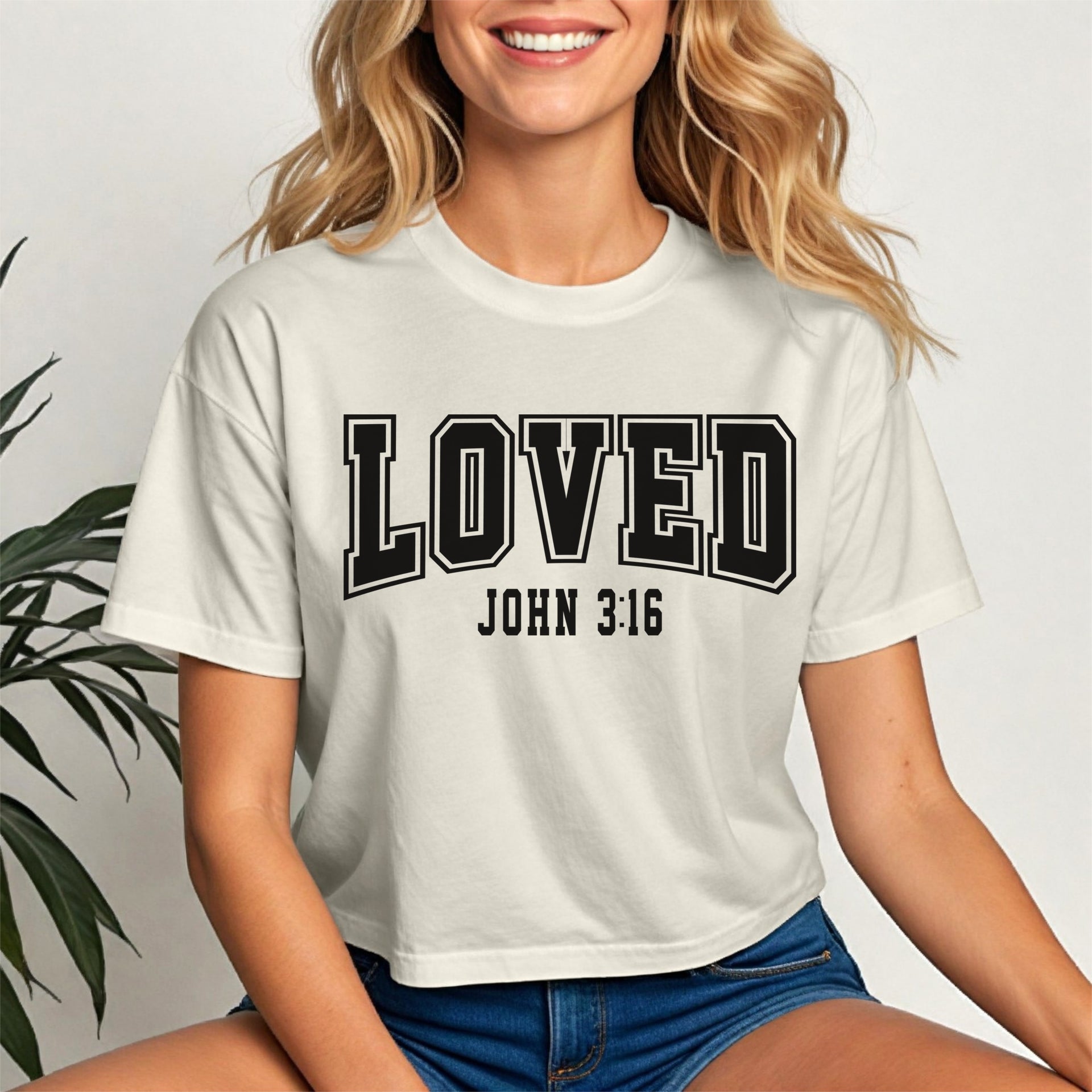 Loved John 3 16 Crop Tee worn by a smiling woman, showcasing its trendy design and comfortable fit.