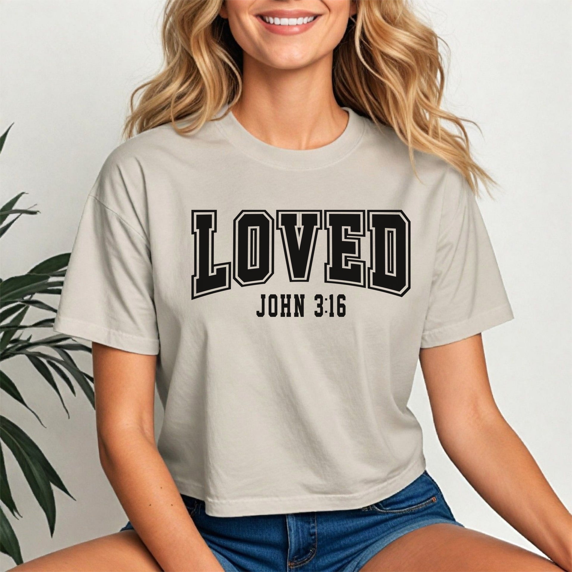 Loved John 3 16 Crop Tee worn by a smiling woman, showcasing its trendy design and comfortable fit.