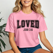 Loved John 3 16 Crop Tee in pink worn by a smiling woman, showcasing its stylish and casual design.