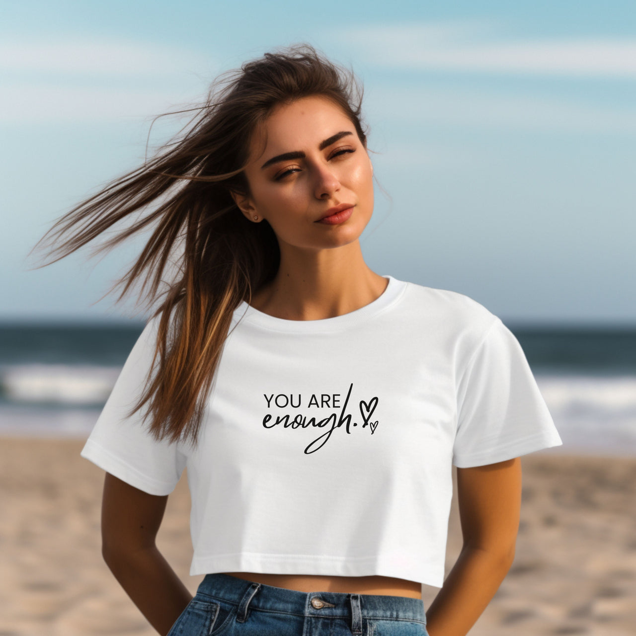 You Are Enough Script Heart Crop Tee worn by model on beach with ocean background.