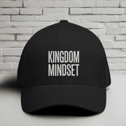 Kingdom Mindset Embroidered Flexfit Hat displayed against a brick wall background.