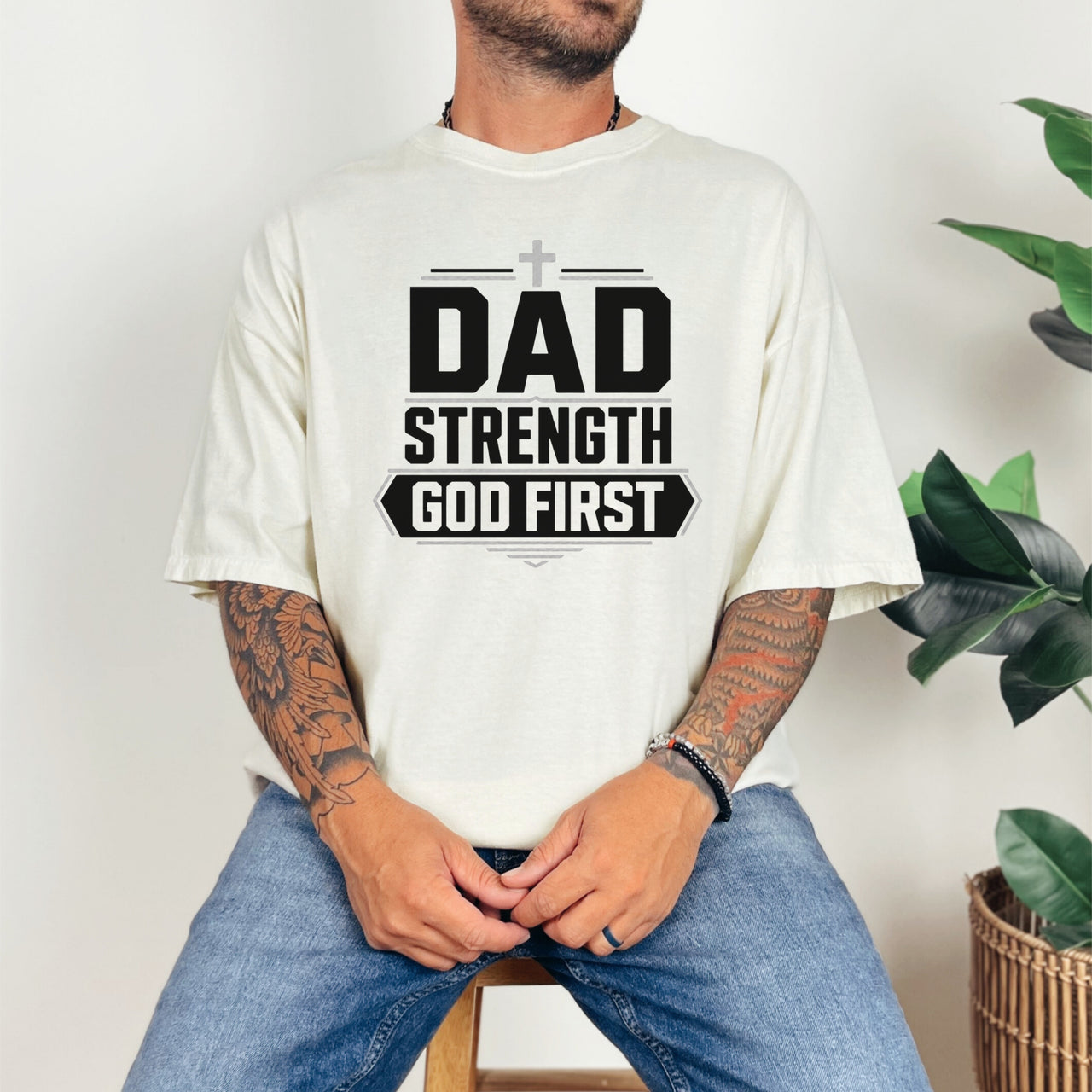 Dad Strength God First T-Shirt worn by a man, featuring bold graphic text, ideal for faith-based casual wear.