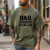 Dad Strength God First T-Shirt worn by a tattooed man in a city setting, emphasizing faith and strength.