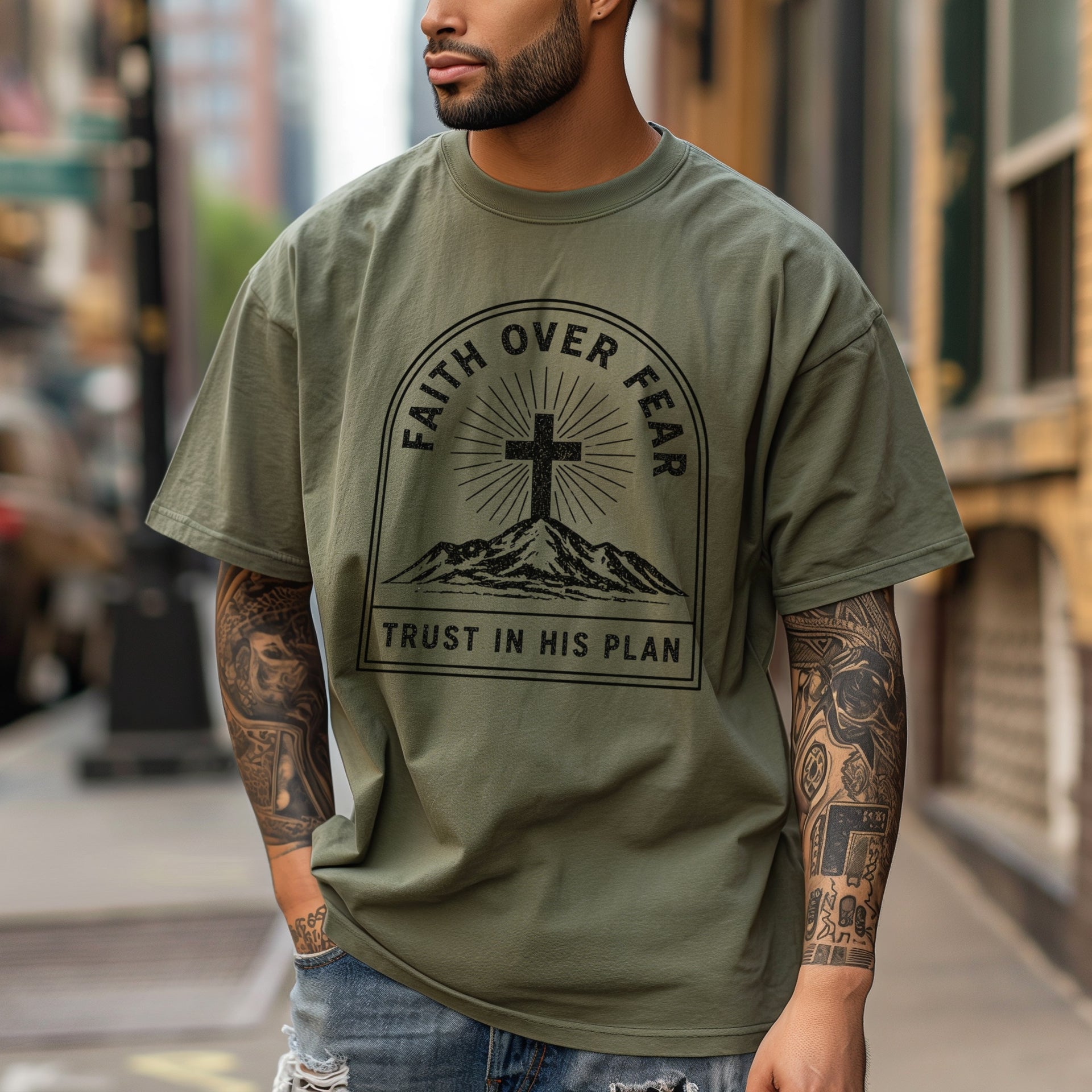 Man wearing Faith Over Fear Trust In His Plan Comfort Colors T Shirt, showcasing faith and courage in a city setting.