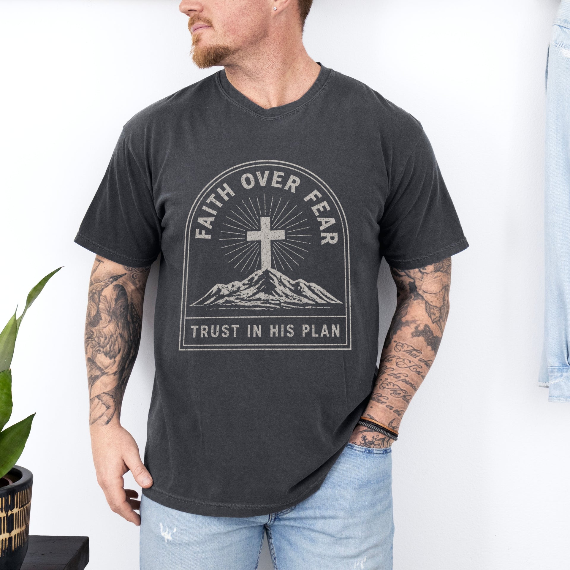 Faith Over Fear Trust In His Plan Comfort Colors T Shirt worn by man with tattoo, featuring cross and mountain design.