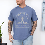 Faith Over Fear Trust In His Plan Comfort Colors T Shirt worn by man with tattoos, blue tee with cross and mountains design.