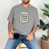 Man Of God Husband Father Leader T Shirt worn by a man holding a coffee cup, showcasing a bold badge design.