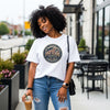 Woman wearing the 250 Years America Badge T-Shirt with vintage badge design and American flag elements.