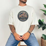 Man wearing 250 Years America Badge T-Shirt featuring vintage badge design and American flag elements.
