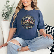 Woman wearing a 250 Years America Badge T-Shirt with a vintage badge design and American flag elements.