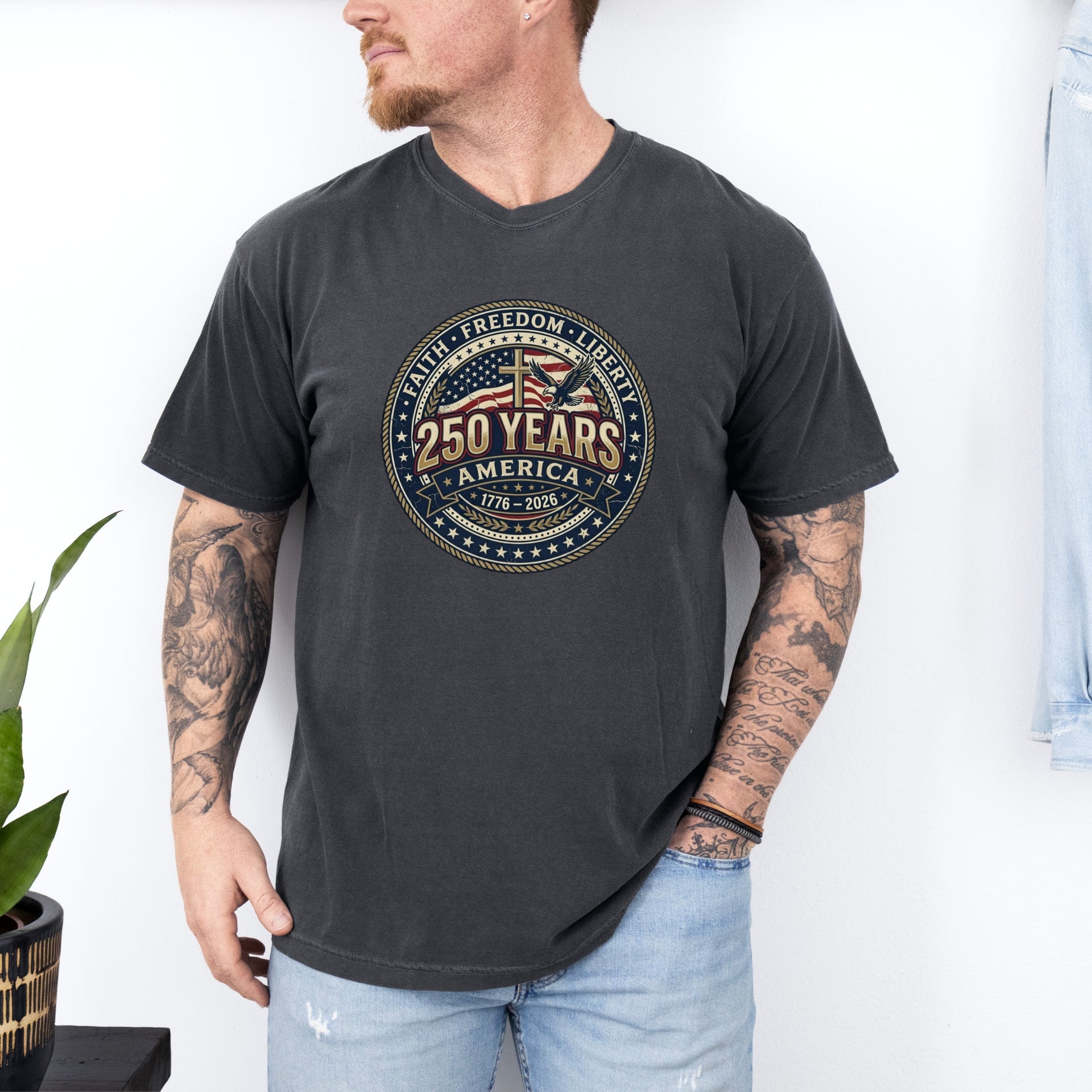 Man wearing a 250 Years America Badge T-Shirt with vintage badge design and American flag inspired elements.