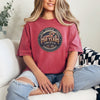 Woman wearing 250 Years America Badge T-Shirt with vintage badge design and American flag elements.