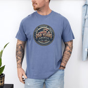 Man wearing a 250 Years America Badge T-Shirt with a vintage badge design and American flag elements.