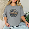 250 Years America Badge T-Shirt worn by a woman, featuring vintage badge design and American flag elements.