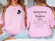 Woman wearing a pink Motherhood Is Kingdom Work T Shirt with silhouette design and inspirational text.