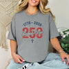 Woman wearing a gray Blessed & Free 250 T-Shirt with patriotic design celebrating freedom.