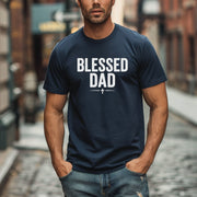 Blessed Dad Cross T Shirt worn by a man in a city setting, featuring bold text design and cross symbol.