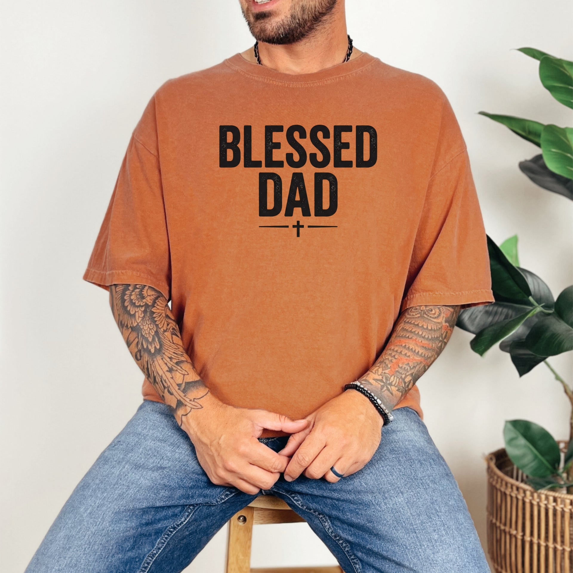 Man wearing a Blessed Dad Cross T Shirt in brown with bold text design, showcasing faith and fatherhood.