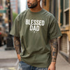 Man wearing a Blessed Dad Cross T Shirt in moss with bold white text and cross design.