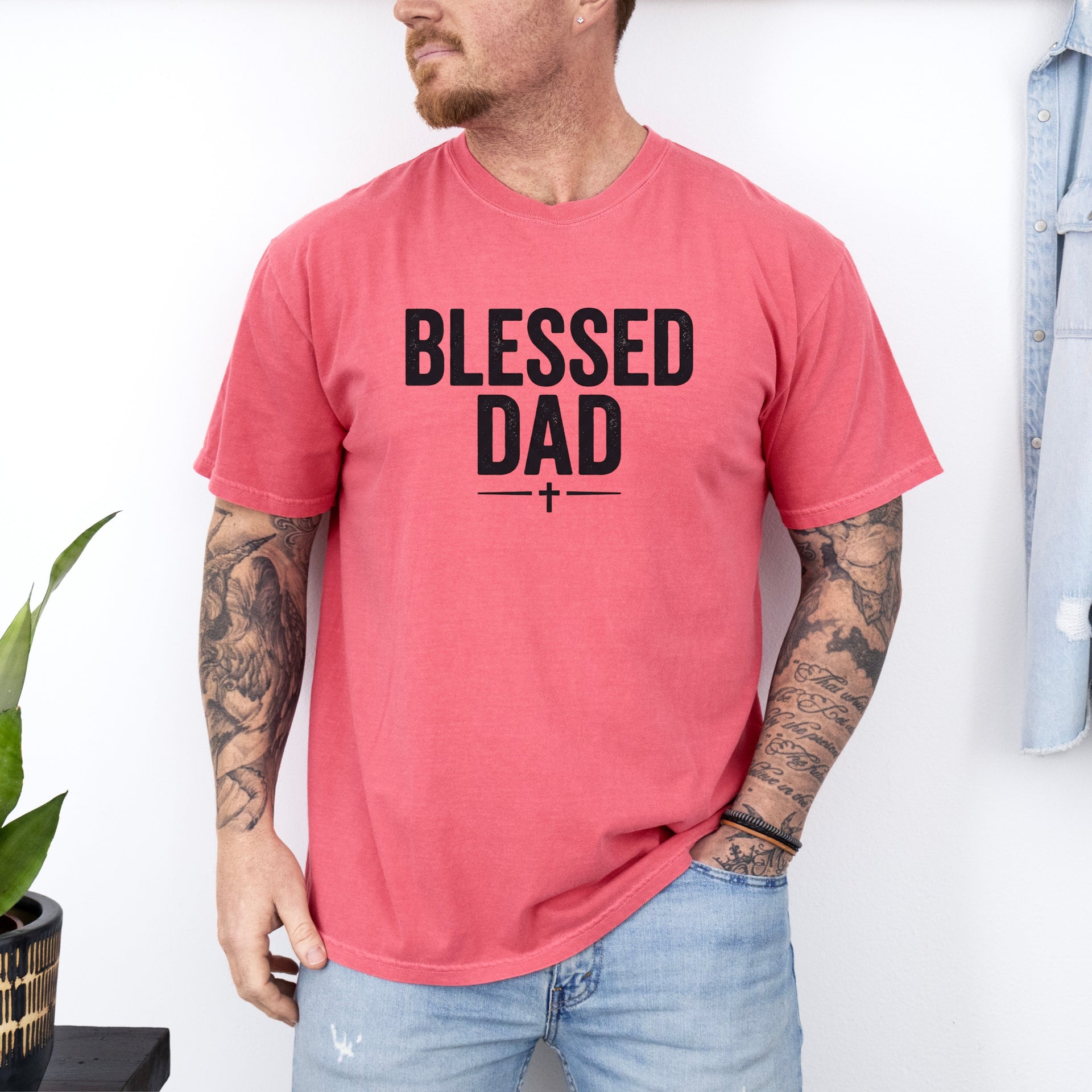 Blessed Dad Cross T Shirt featuring a bold cross design, worn by a man with tattoos in a casual setting.
