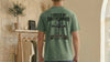 Man wearing a Forged By Brotherhood Cross T Shirt, showcasing Christian brotherhood apparel with a bold cross design.