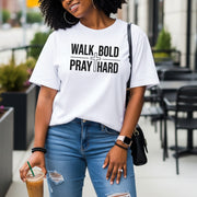 Woman wearing Walk Bold Pray Hard Christian cross t shirt, showcasing faith and style in a casual urban setting.