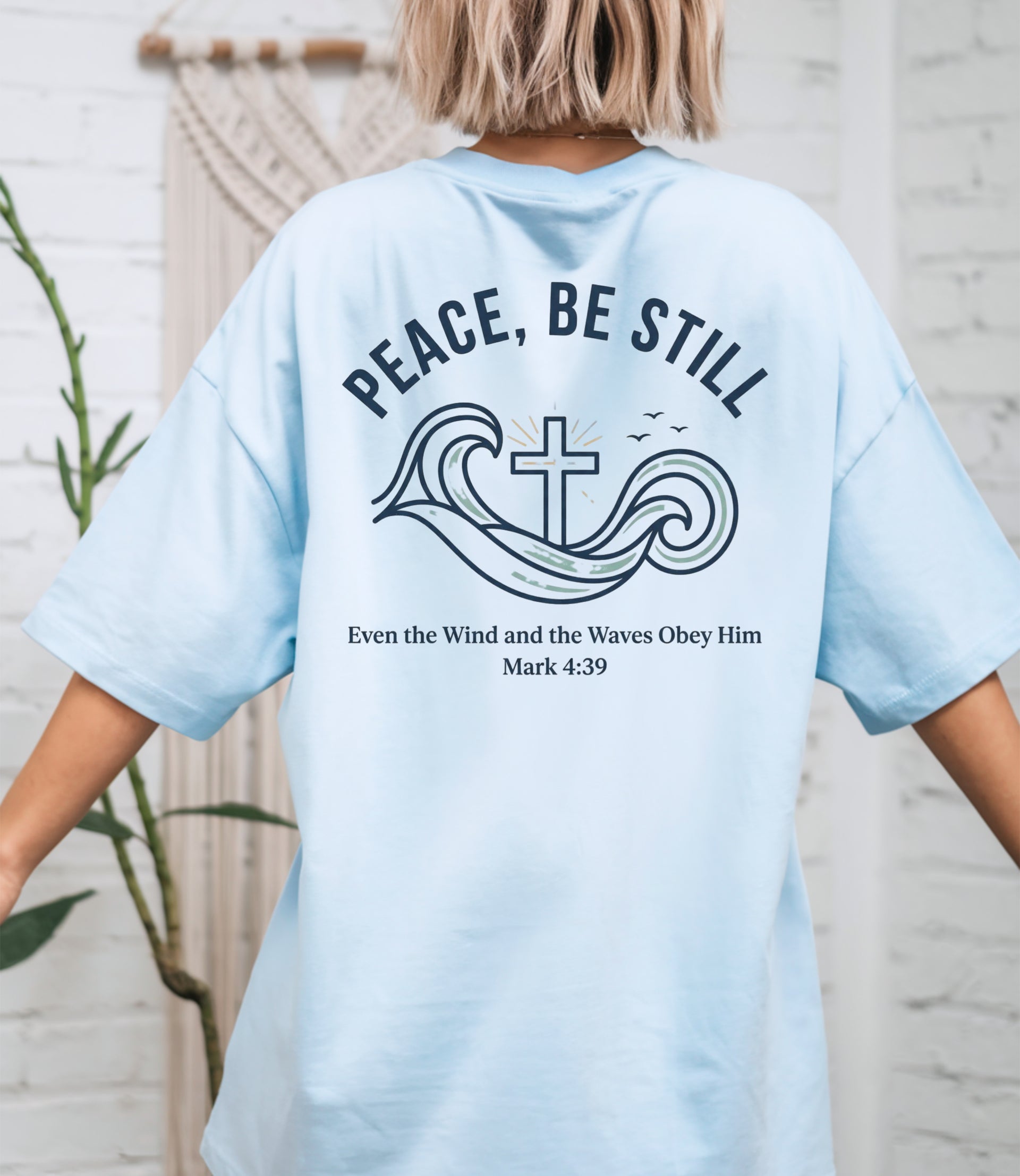 Peace Be Still T Shirt featuring waves and a cross design, perfect for conveying calm and comfort.