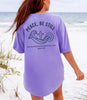Peace Be Still T Shirt displayed on a woman with ocean background, featuring a cross and calming waves design.