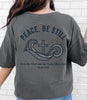 Peace Be Still T Shirt featuring a design with waves and a cross, perfect for expressing faith and comfort.