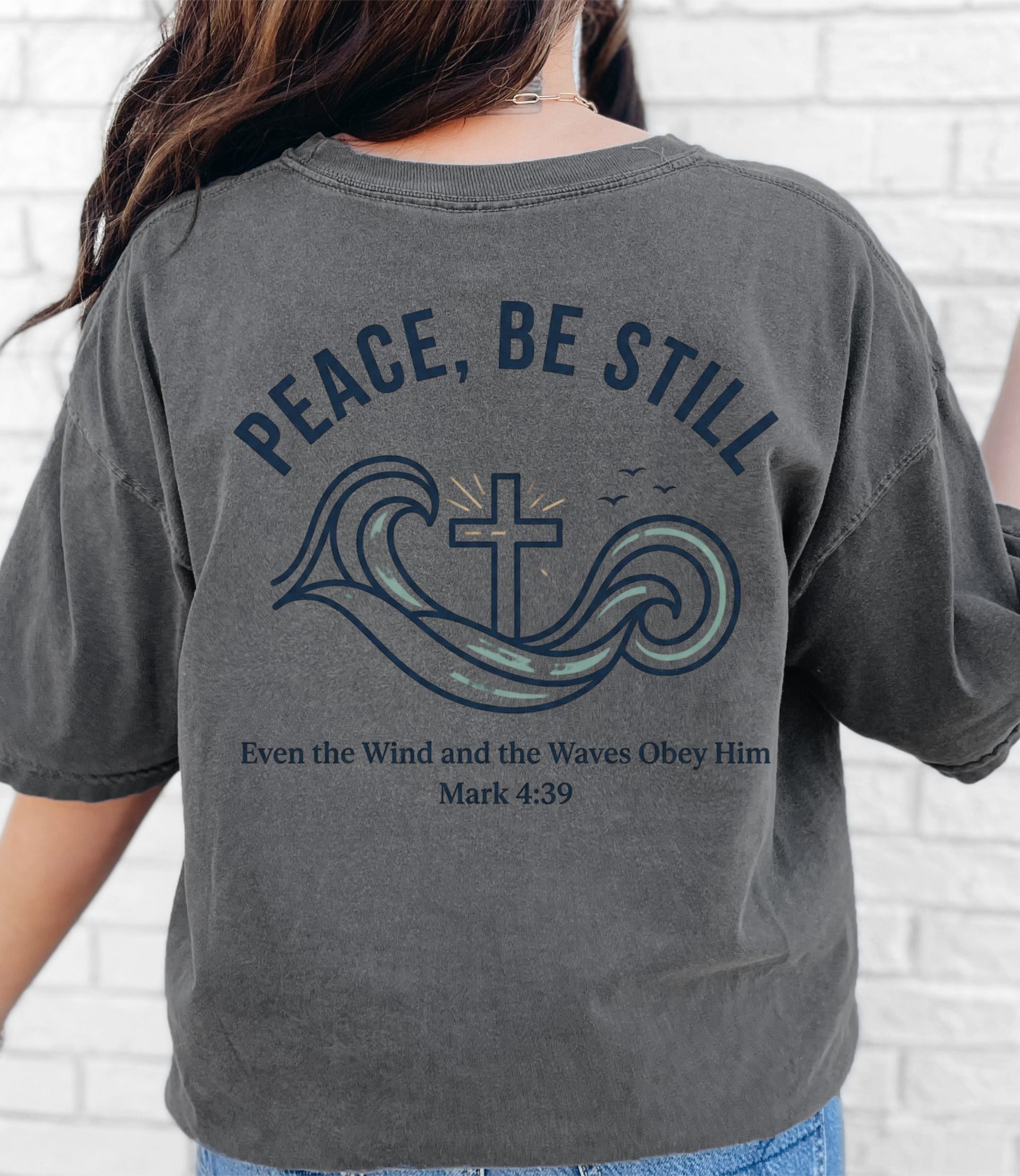 Peace Be Still T Shirt featuring a design with waves and a cross, perfect for expressing faith and comfort.