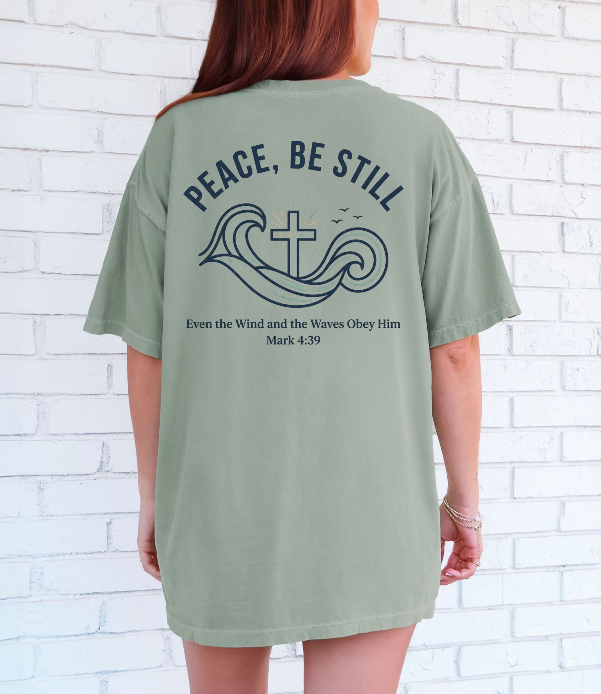 Peace Be Still T Shirt featuring a calming design with waves and cross, perfect for expressing faith and comfort.