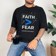 Man wearing a black Faith > Fear T shirt with a cup, promoting faith over fear t shirt message.