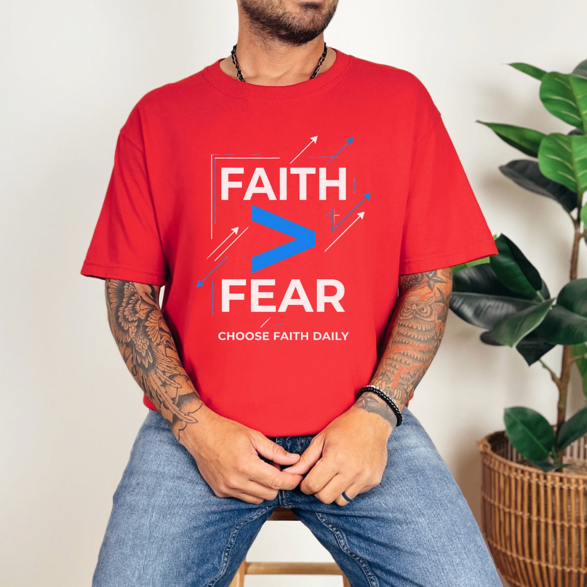 Man wearing a red Faith > Fear T shirt, promoting faith over fear t shirt with a bold design.
