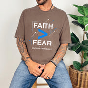 Man wearing a brown Faith > Fear T shirt promoting courage with the slogan "Choose Faith Daily".