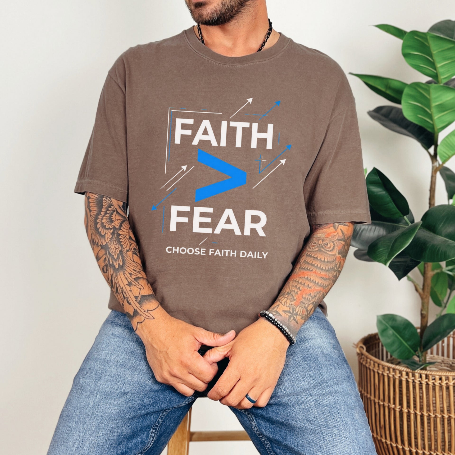 Man wearing a brown Faith > Fear T shirt promoting courage with the slogan "Choose Faith Daily".