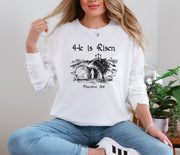 He Is Risen long sleeve t-shirt featuring Matthew 28:6 design on a woman, symbolizing resurrection and hope.