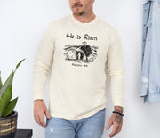 He Is Risen long sleeve t-shirt featuring a Christian message and illustration from Matthew 28:6.